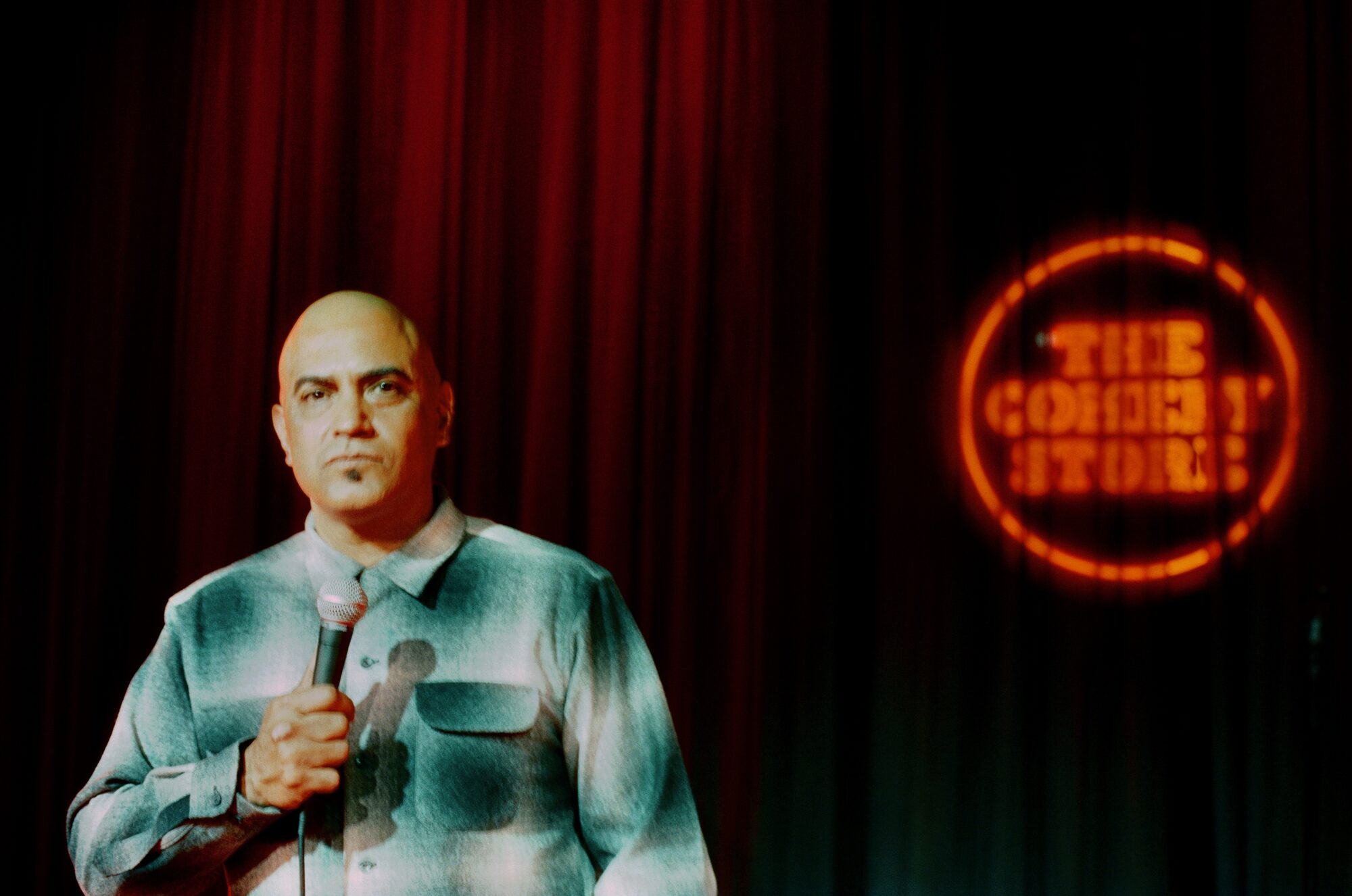 George Perez performing stand-up on stage at The Comedy Store